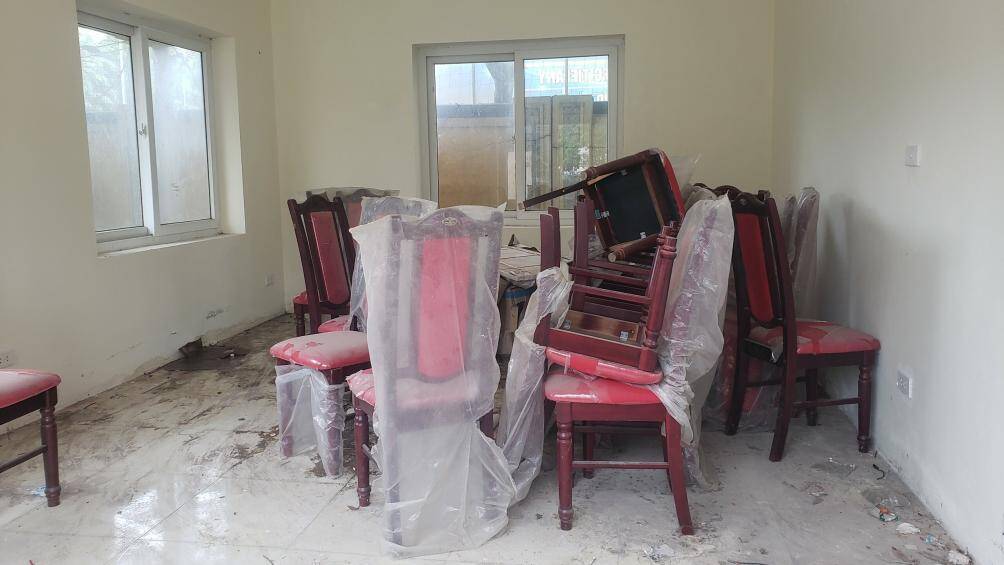 Tại khu vực được cho l&agrave; nh&agrave; điều h&agrave;nh c&oacute; nhiều b&agrave;n ghế vứt ngổn ngang, bụi bẩn.