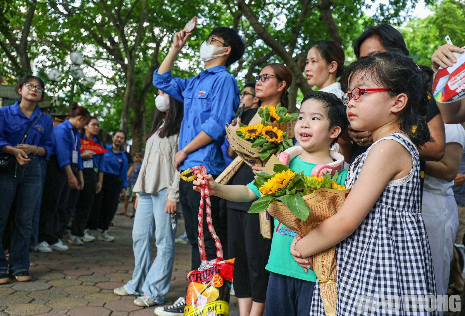&Ocirc;m b&oacute; hoa đợi anh trai b&ecirc;n ngo&agrave;i điểm thi trường THPT Phan Đ&igrave;nh Ph&ugrave;ng (quận Ba Đ&igrave;nh), hai b&eacute; Diệu Linh v&agrave; Nhật Minh hy vọng anh trai của m&igrave;nh sẽ l&agrave;m b&agrave;i thật tốt