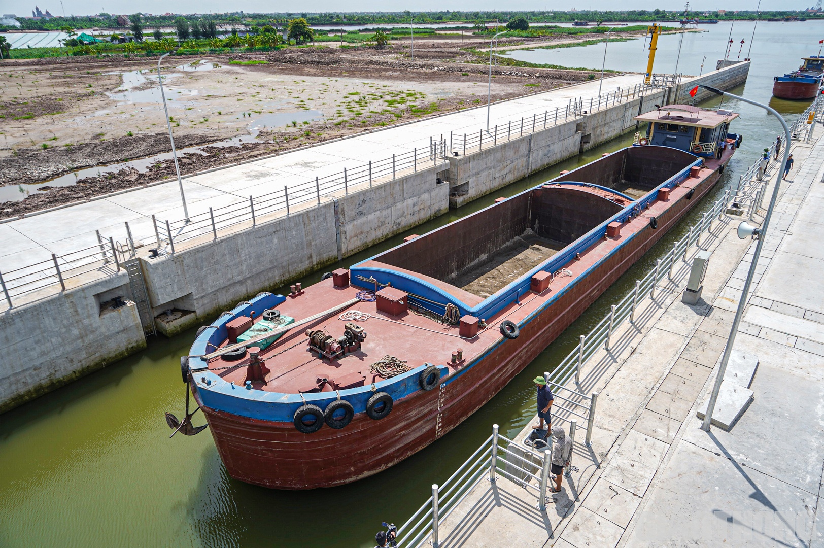 &Ocirc;ng Nguyễn Văn H&ugrave;ng (x&atilde; Nghĩa Sơn, huyện Nghĩa Hưng), chủ t&agrave;u ki&ecirc;m thuyền trưởng t&agrave;u NĐ-4002 cho biết, khi c&oacute; &acirc;u t&agrave;u, t&agrave;u lưu th&ocirc;ng từ thượng nguồn hoặc hạ nguồn xuống an to&agrave;n hơn. V&igrave; t&agrave;u c&oacute; tải trọng lớn, 820 tấn n&ecirc;n nếu phải đi qua k&ecirc;nh kh&aacute;c sẽ xa hơn, mất th&ecirc;m nửa ng&agrave;y v&agrave; kh&aacute; rất nguy hiểm. (Trong ảnh: T&agrave;u NĐ-4002 đang v&agrave;o &acirc;u để neo đậu)