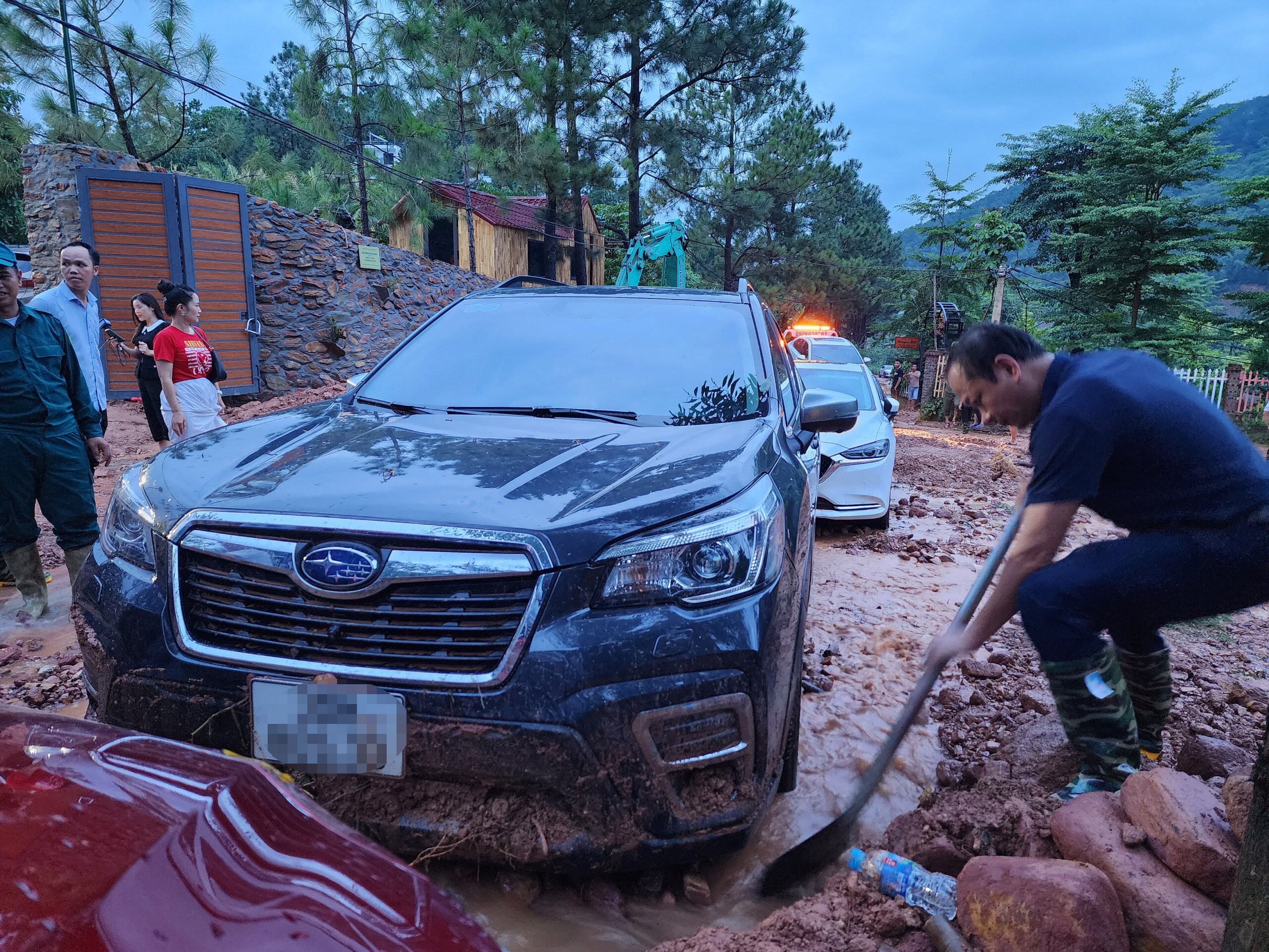 Thời điểm lở đất, trời mưa to, c&oacute; nhiều &ocirc; t&ocirc; dừng đỗ ăn uống ở c&aacute;c nh&agrave; h&agrave;ng ven đường n&ecirc;n đ&atilde; bị mắc kẹt khi đất đ&aacute; bủa v&acirc;y.