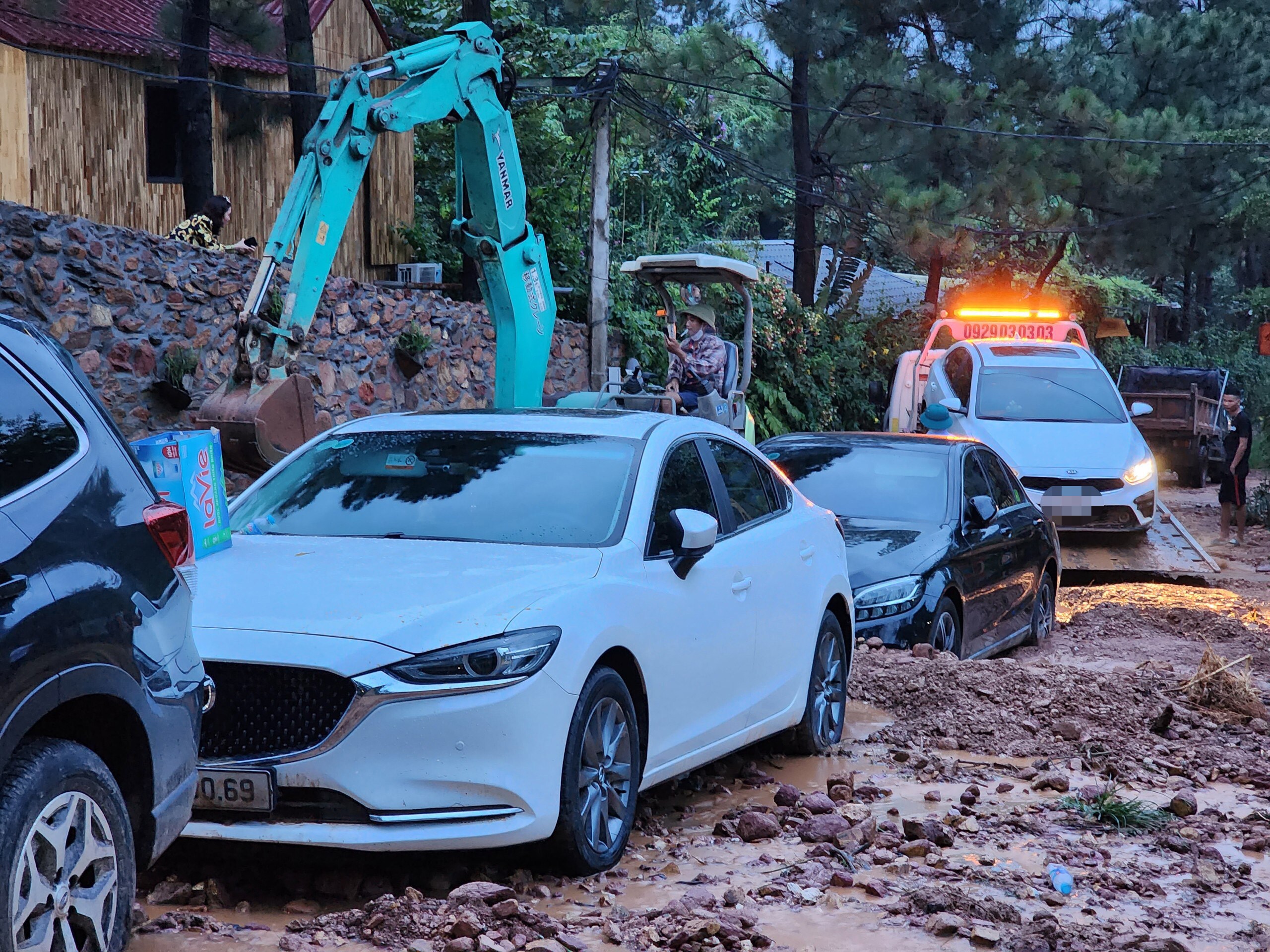 Chị N. (tr&uacute; tại nội th&agrave;nh H&agrave; Nội), người c&oacute; chiếc xe &ocirc; t&ocirc; mắc kẹt tại đ&acirc;y cho biết: "Gia đ&igrave;nh t&ocirc;i v&agrave; bạn b&egrave; l&ecirc;n đ&acirc;y chơi từ s&aacute;ng, l&uacute;c đ&oacute; mưa nhỏ. Gần trưa, mưa to, nước chảy xối xả ở đường. Thấy vậy, mọi người hốt hoảng nhớ đến mấy chiếc xe &ocirc; t&ocirc; để ở vệ đường, khi nh&igrave;n ra th&igrave; đ&atilde; thấy đất đ&aacute; bủa v&acirc;y đầy xe".