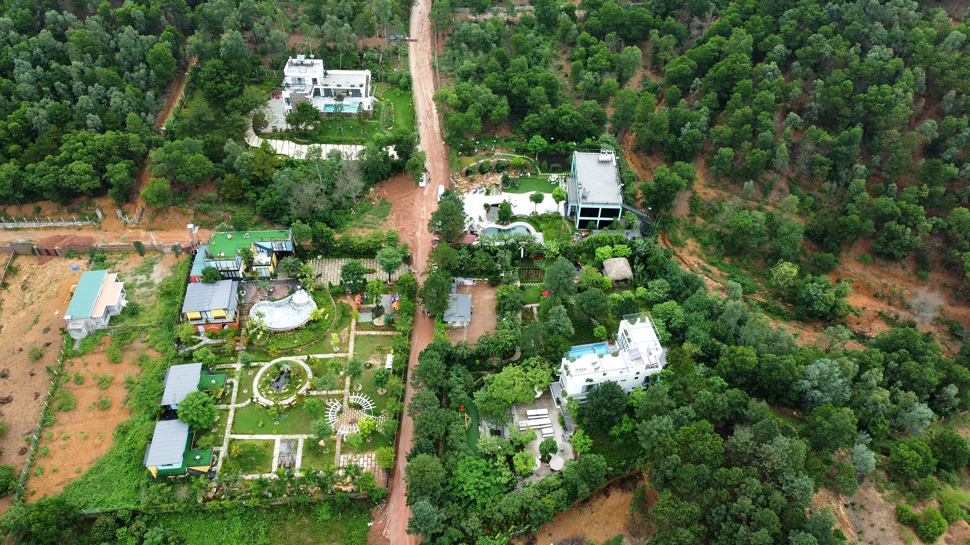 Hai b&ecirc;n con đường b&ecirc; t&ocirc;ng rộng khoảng 8m nơi xảy ra sự cố đất đ&aacute; lở bủa v&acirc;y h&agrave;ng chục &ocirc; t&ocirc; l&agrave; bốn tổ hợp c&ocirc;ng tr&igrave;nh ki&ecirc;n cố dạng homestay.