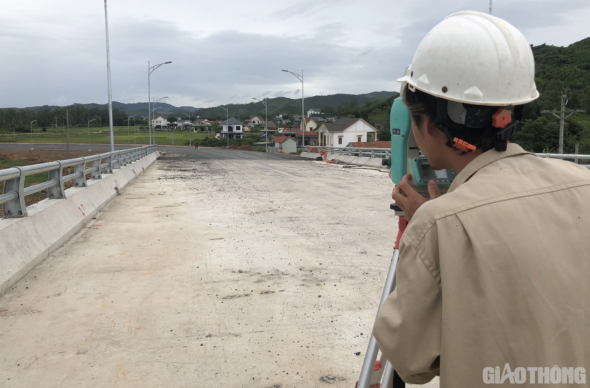 Kỹ sư trắc địa Phạm Văn Vinh, C&ocirc;ng ty Ho&agrave; Hiệp đang x&aacute;c định tim đường dẫn n&uacute;t giao l&ecirc;n xuống trước khi thảm lớp cuối c&ugrave;ng của phần đường dẫn.