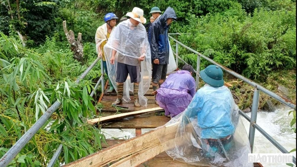 Lực lượng d&acirc;n qu&acirc;n tham gia sửa chữa cầu treo bị hư hỏng do lũ g&acirc;y ra.