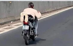 Nằm trên yên để điều khiển xe, cả mẹ và con đều bị xử phạt