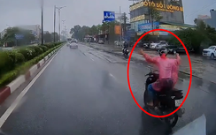Thanh niên vừa lái xe máy, vừa dang hai tay giữa trời mưa