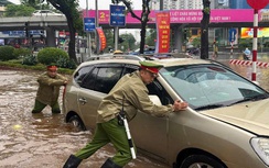 Công an Hà Nội dầm mưa phân luồng, hỗ trợ người dân qua vùng ngập