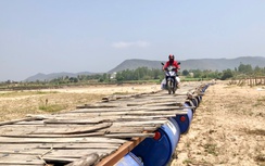 Chờ cầu xây mới, người dân lấy thùng phi ghép gỗ làm cầu tạm vượt sông Ba