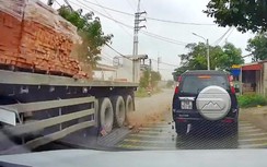 Ô tô con phanh gấp vì gạch trên xe tải rơi xuống đường
