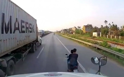 Hai thanh niên đầu trần đi xe máy đánh võng trước đầu xe container