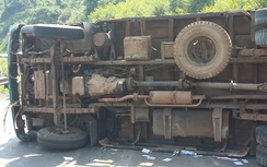 Tông xe máy, xe tải chở quan tài lật ngang đường