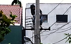 Hãi hùng nam thanh niên ngồi trên đỉnh cột điện dưới trời mưa