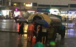 Cư dân Linh Đàm đội mưa nhọc nhằn hứng từng can nước