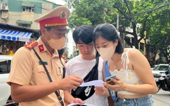Cận cảnh CSGT phát tờ rơi song ngữ tuyên truyền ATGT ở phố đường tàu