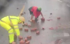 Cảnh sát giao thông dầm mưa hỗ trợ người dân dọn gạch để xe đi an toàn