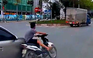 Không đội mũ bảo hiểm, nam thanh niên đi xe máy luồn lách, va chạm hai ô tô rồi bỏ đi