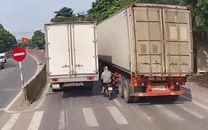 Thót tim cảnh thanh niên đi xe máy cố luồn lách giữa hai xe tải rồi lại vượt phải