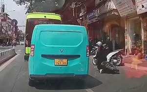 Vừa đi xe máy vừa xem điện thoại, cô gái ngã nhào giữa đường