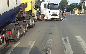 Dừng ngay trước đầu xe đầu kéo, người đi xe máy suýt mất mạng