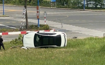 TP.HCM: Mercedes băng qua ngã tư, tông gãy cây xanh rồi lật nhào lên bãi cỏ ven đường