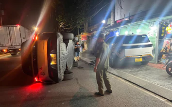 TP.HCM: Taxi lao lên vỉa hè, tông ô tô rồi lật nghiêng