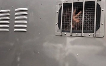 Châu Việt Cường giơ ngón tay chào người thân trên xe bịt bùng